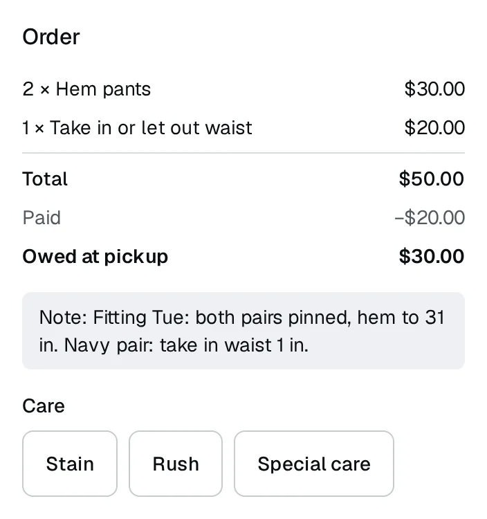A tailor's ticket: two pairs of pants to hem and a waist to take in, the fitting note underneath, a deposit paid and the rest owed at pickup.